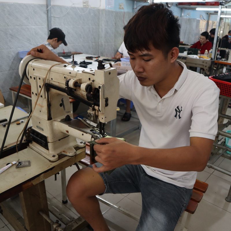 Thợ may lành nghề đang thực hiện công đoạn chần chỉ trên chiếc túi du lịch da